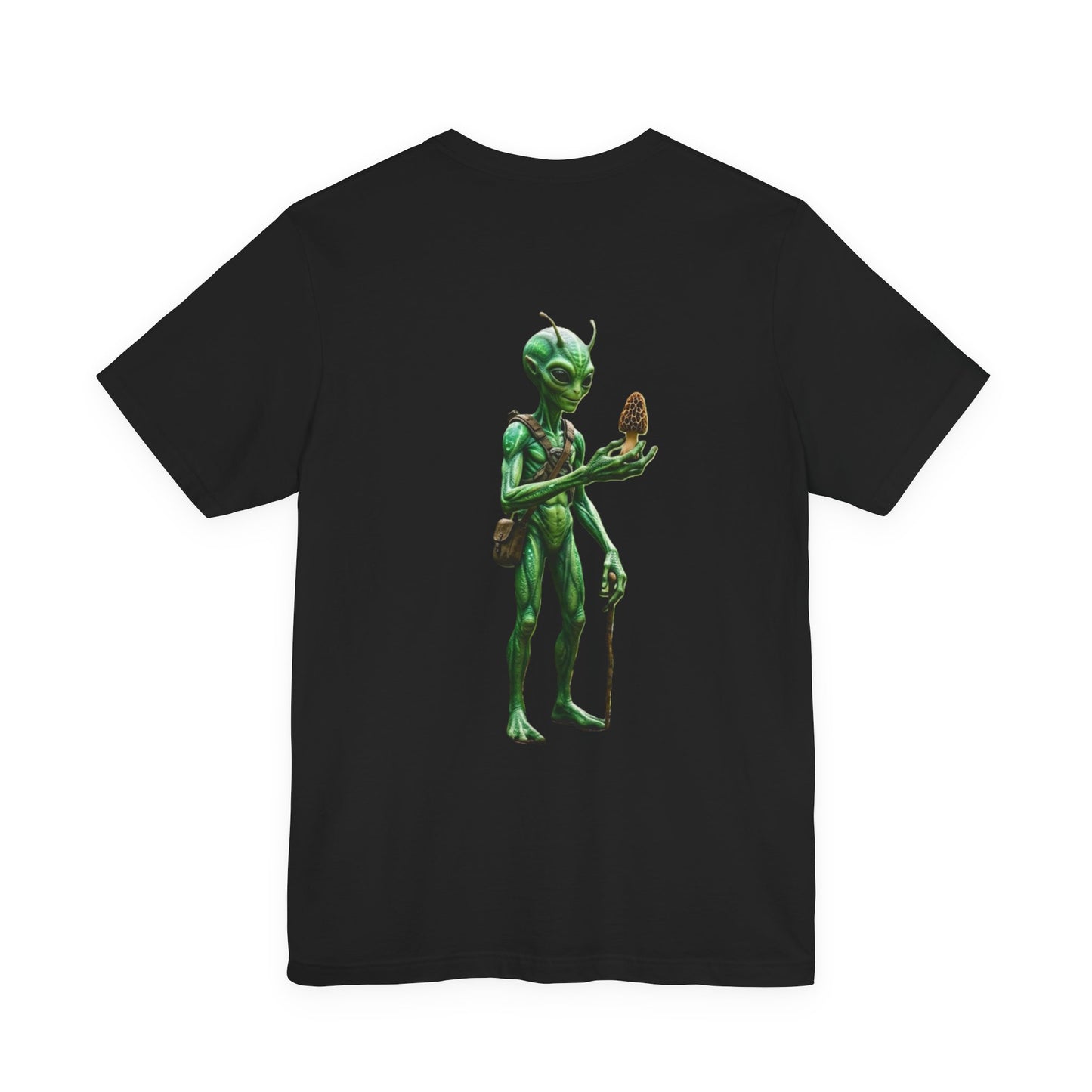 Green alien character with a leather bag holding up a morel mushroom on a black t-shirt.