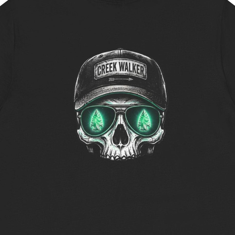  Distressed human skull graphic on a black shirt wearing a Creek Walker baseball cap and aviator sunglasses reflecting a glowing green arrowhead