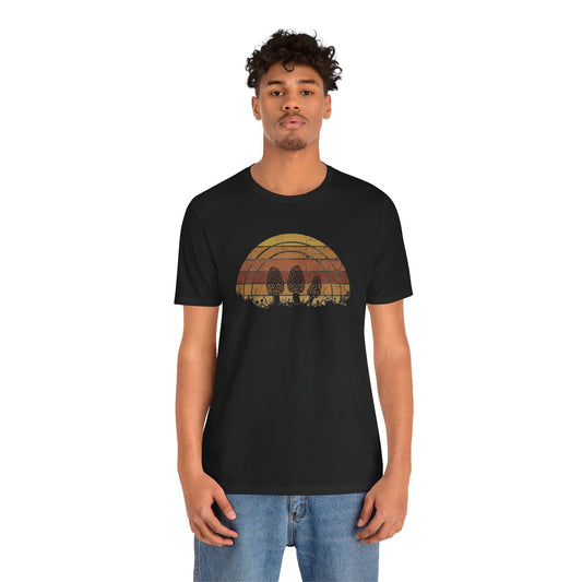 Retro vintage sunset graphic with three morel mushrooms on a black t-shirt.